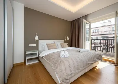 a bedroom with a large bed and a balcony at Wishlist Prague Residences - Old Town Dlouha in Prague