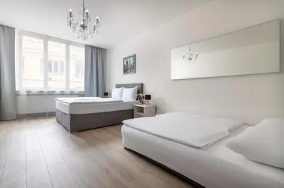 a bedroom with two beds and a chandelier at Prague Serenity Suites and Apartments in Prague
