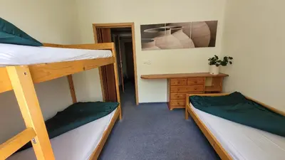 a room with two bunk beds and a desk at Pension Patanka in Prague