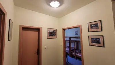 a room with a hallway with a door and pictures on the walls at Pension Patanka in Prague