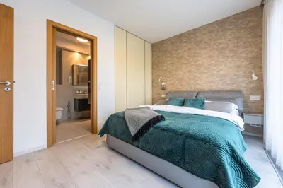a bedroom with a large bed and a bathroom at Wishlist Prague Residences - Karlín FREE PARKING in Prague