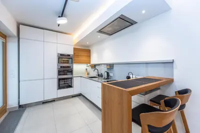 a kitchen with white cabinets and a wooden counter top at Wishlist Prague Residences - Karlín FREE PARKING in Prague