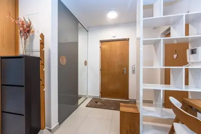 a hallway with white walls and a wooden door at Wishlist Prague Residences - Karlín FREE PARKING in Prague
