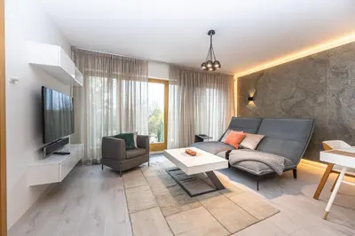 a living room with a couch and a tv at Wishlist Prague Residences - Karlín FREE PARKING in Prague