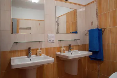 a bathroom with two sinks and a mirror and blue towels at Penzion U Vinotéky in Nymburk