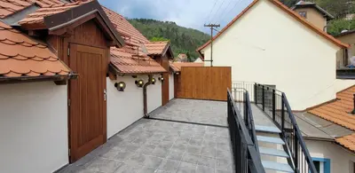 a walkway between two buildings with roofs at Bunkr Karlštejn - Modrý dům in Karlštejn