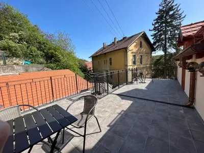 a balcony with a bench and a building at Bunkr Karlštejn - Modrý dům in Karlštejn