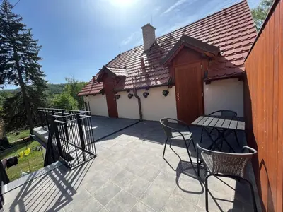 a patio with chairs and a table and a building at Bunkr Karlštejn - Modrý dům in Karlštejn