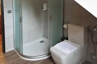 a small bathroom with a toilet and a shower at Bunkr Karlštejn - Modrý dům in Karlštejn