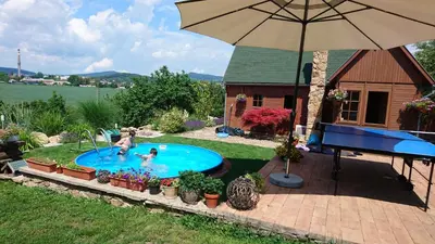 two people playing in a swimming pool with an umbrella at Na vyhlidce in Litoměřice