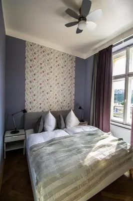 a bedroom with a bed with a ceiling fan at 3BDR City Center Ruterra Apartment in Prague
