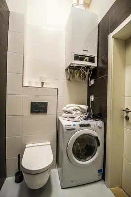 a bathroom with a washing machine and a toilet at 3BDR City Center Ruterra Apartment in Prague