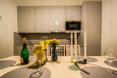a kitchen with a table with wine bottles and flowers at 3BDR City Center Ruterra Apartment in Prague