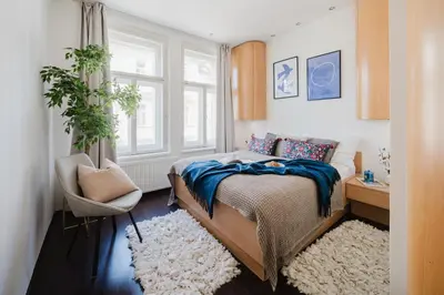a bedroom with a bed and a chair and a window at Prague Days - Open-plan Apartment with Netflix in Žižkov in Prague