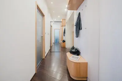 a hallway with white walls and a wooden table in a room at Prague Days - Open-plan Apartment with Netflix in Žižkov in Prague