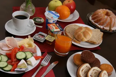 a table with plates of breakfast foods and a cup of coffee at Hotel Klara in Prague