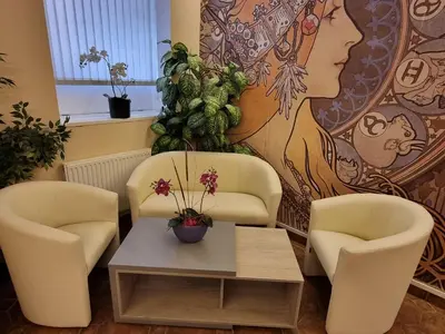 two chairs and a table in a room with a mural at Hotel Klara in Prague