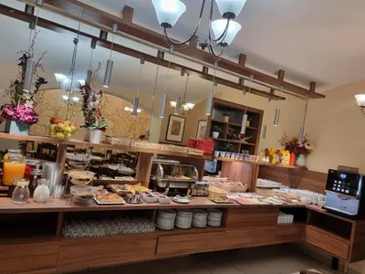 a restaurant with a counter with food on it at Hotel Klara in Prague
