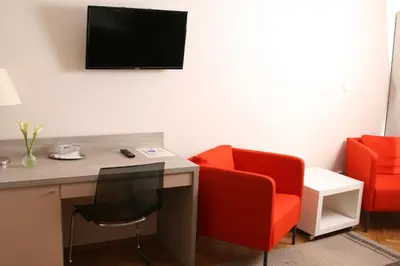 a room with a desk and two red chairs at Hotel Klara in Prague