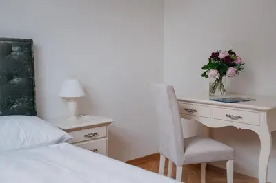 a bedroom with a desk with a vase of flowers at High Heaven in Prague