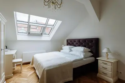 a bedroom with a bed with white sheets and a window at High Heaven in Prague