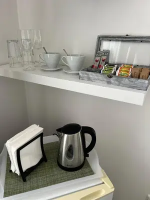 a tea kettle on a shelf in a kitchen at Penzion Marjána in Mníšek pod Brdy