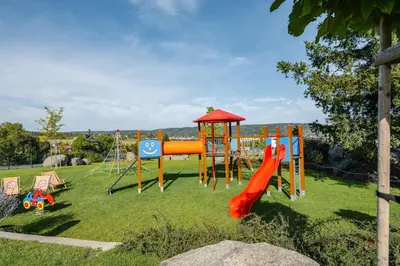 a park with a playground with a slide at Penzion Marjána in Mníšek pod Brdy