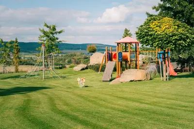 a park with a playground with a slide at Penzion Marjána in Mníšek pod Brdy