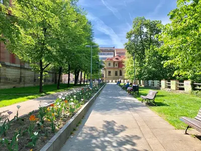 a park with benches and flowers on a sidewalk at CE Apartment Prague Castle in Prague