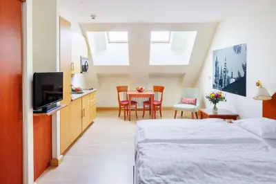 a bedroom with a bed and a table and chairs at Hapimag Apartments Prague in Prague