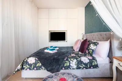 a bedroom with a bed with a tv on it at Romantic designer apartment Prague in Prague