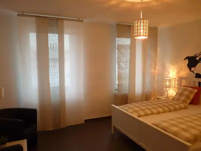 a bedroom with a bed with windows and a chandelier at The modern apartment in Prague