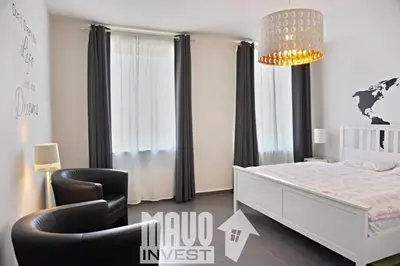 a bedroom with a bed and a chair and a chandelier at The modern apartment in Prague