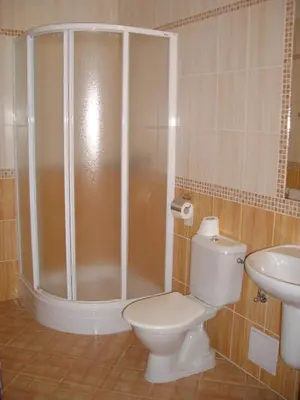a bathroom with a shower and a toilet and a sink at Parkhotel Terezín in Terezín