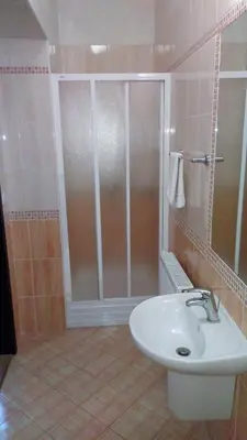 a bathroom with a shower and a white sink at Parkhotel Terezín in Terezín
