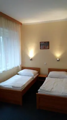 two twin beds in a room with a window at Parkhotel Terezín in Terezín