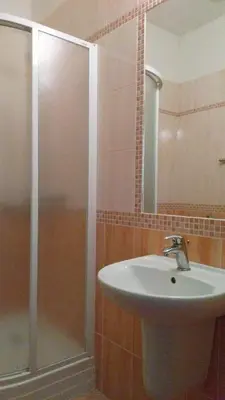 a bathroom with a sink and a shower with a mirror at Parkhotel Terezín in Terezín