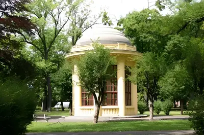 a building with a dome in the middle of trees at Parkhotel Terezín in Terezín