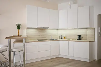 a white kitchen with a sink and a counter at Luxury Center Apt. Charles bridge walking distance in Prague
