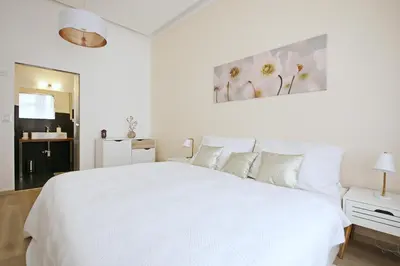 a white bedroom with a large white bed with pillows at Luxury Center Apt. Charles bridge walking distance in Prague