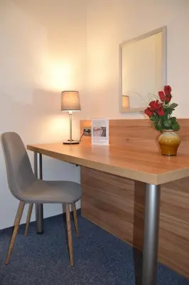 a desk with a chair and a lamp and a mirror at Hotel Bohemians in Prague