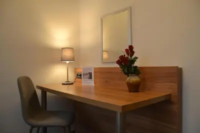 a desk with a vase of flowers and a lamp at Hotel Bohemians in Prague