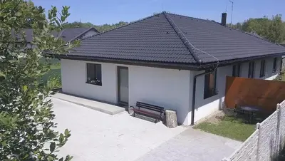 a small white house with a black roof at Apartmán Dubová in Milovice