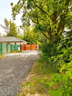 a gravel road with a fence and a tree at Apartmán Dubová in Milovice