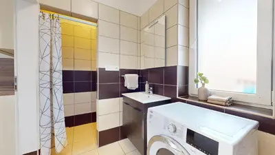 a bathroom with a washing machine and a sink at Apartmán Dubová in Milovice