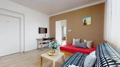 a living room with a couch and a red bed at Apartmán Dubová in Milovice