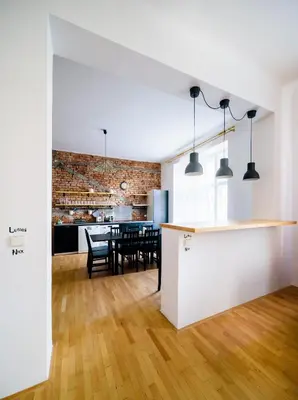 a kitchen and dining room with white walls and wood floors at Amazing Harry Potter's apt. at Old Town in Prague