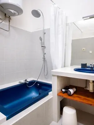 a bathroom with a blue tub and a sink at Amazing Harry Potter's apt. at Old Town in Prague