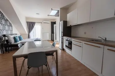 a kitchen with white cabinets and a table with chairs at Andel Centre SPIRIT in Prague