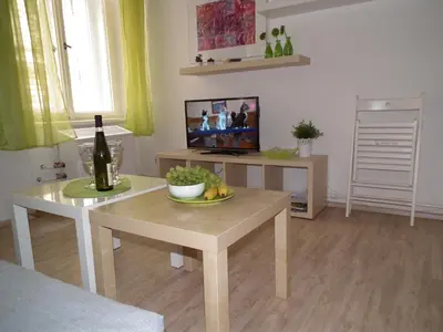 a living room with a table with a bottle of wine at Apartment in the centre in Prague